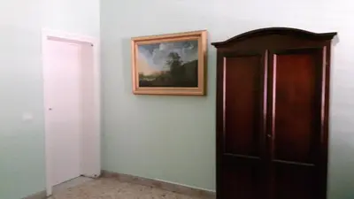 a room with a painting and a wooden door at Profumo di Sicilia in Palermo