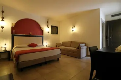 a bedroom with a bed and a couch at RIAD Comfort Rooms in San Vito lo Capo