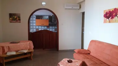 a living room with a red couch and a door at Casa Josephine in Balestrate