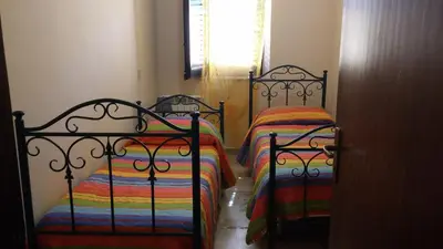 two beds with colorful sheets in a room at Casa Josephine in Balestrate