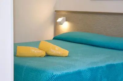 a bed with two yellow pillows on top of it at La Blanca Resort & Spa in Castellammare del Golfo
