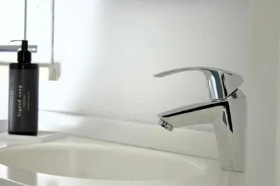 a bathroom sink with a black soap dispenser on it at La Blanca Resort & Spa in Castellammare del Golfo