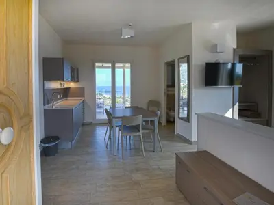 a kitchen and living room with a table and chairs at La Blanca Resort & Spa in Castellammare del Golfo