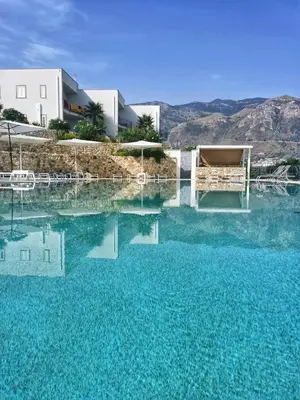 a large pool of blue water in front of a building at La Blanca Resort & Spa in Castellammare del Golfo