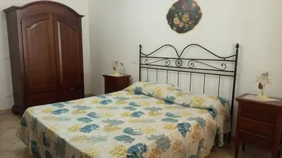 a bedroom with a bed with a floral bedspread at Case nel Giardino in San Vito lo Capo