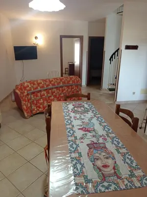 a living room with a couch and a table at Case nel Giardino in San Vito lo Capo