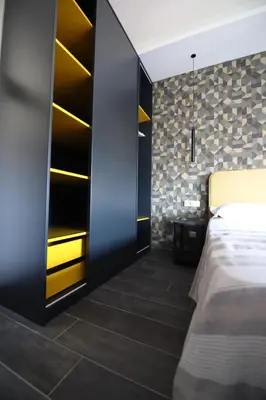 a bedroom with a bed and a wall with shelves at Le Cupole Design in Palermo