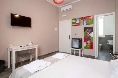 a bedroom with a bed and a desk and a tv at Le Cupole Design in Palermo