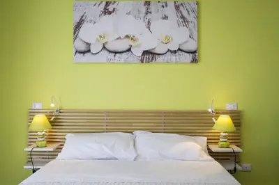 a bedroom with a bed with two lamps and a painting on the wall at Le Cupole Design in Palermo