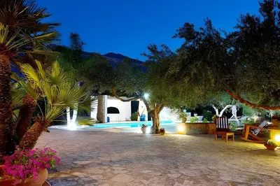 two chairs and a table next to a swimming pool at Villa Le Sterlizie in Castellammare del Golfo