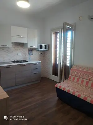 a living room with a couch and a kitchen at Il Peperoncino in San Vito lo Capo