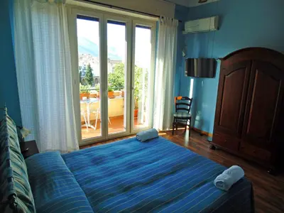a bedroom with a large bed and a large window at Kemonia in Palermo