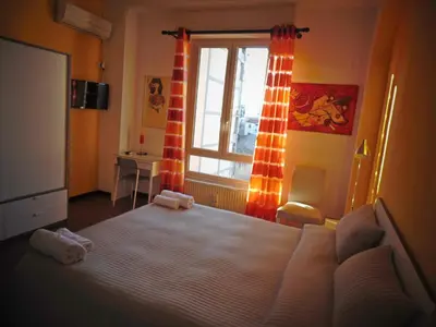 a bedroom with a large bed and a window at Kemonia in Palermo