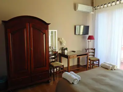 a bedroom with a bed and a desk and a table at Kemonia in Palermo