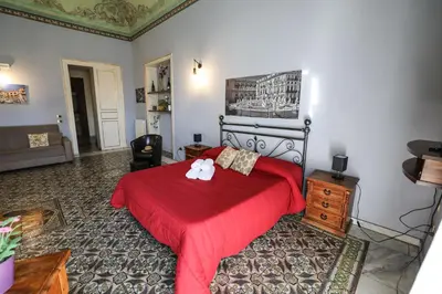 a bedroom with a red bed with a red blanket at Antica Dimora in Palermo