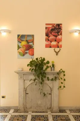a fireplace in a room with three paintings on the wall at Antica Dimora in Palermo