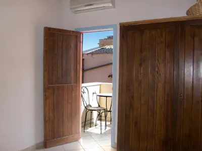 a door to a room with a table and a chair at Soleluna in Castellammare del Golfo