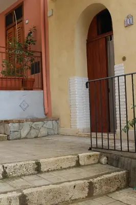 an entrance to a building with a wooden door and stairs at Soleluna in Castellammare del Golfo