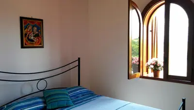 a bedroom with a bed and two windows at Il Gelsomino Home Holiday in Alcamo