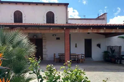 a white house with a porch with a table at Il Gelsomino Home Holiday in Alcamo