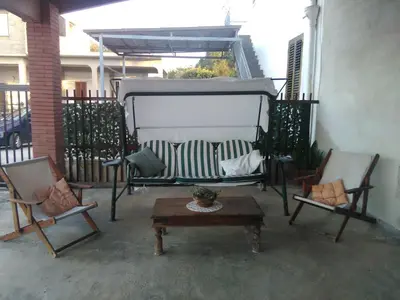 a porch with two chairs and a table on a balcony at Il Gelsomino Home Holiday in Alcamo