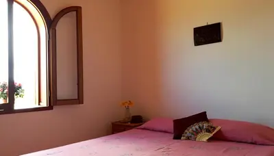 a bedroom with a bed and a mirror and a window at Il Gelsomino Home Holiday in Alcamo