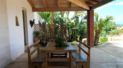 a wooden table and chairs on a patio at Il Gelsomino Home Holiday in Alcamo
