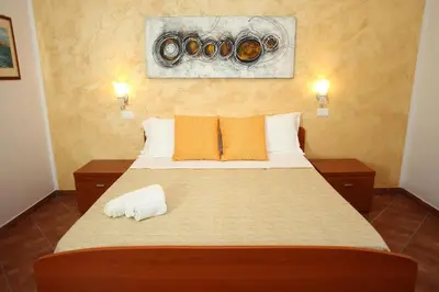 a bedroom with a bed with two cameras on the wall at Country Villa San Vito Bay in San Vito lo Capo