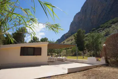 a house with a mountain in the background at Villetta Blusanvito in San Vito lo Capo