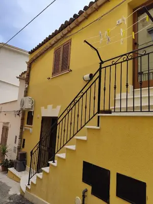 a yellow building with stairs on the side of it at La Perla sul Golfo in Castellammare del Golfo