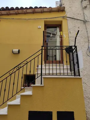 a yellow building with a staircase and a window at La Perla sul Golfo in Castellammare del Golfo