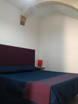 a bedroom with a blue bed in a white room at I due Archi in Castellammare del Golfo