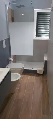 a bathroom with two toilets and a sink and a window at La perla della Conca d'Oro in Palermo
