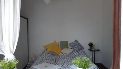 a room with a bed with pillows and a window at Villa Maria in Mondello