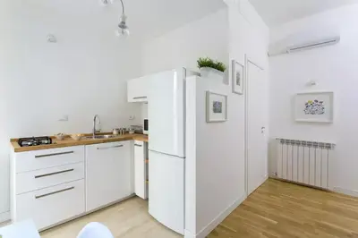 a kitchen with white cabinets and a refrigerator at BB4U Apartments in Palermo