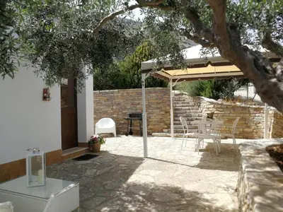 a patio with an umbrella and a table and chairs at Villa Rossana in Scopello