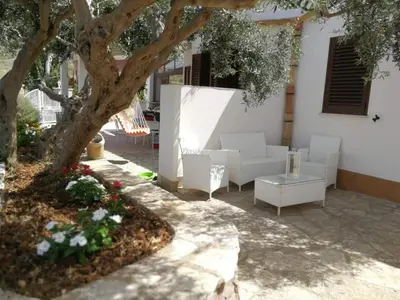 a living room with a white couch and a tree at Villa Rossana in Scopello