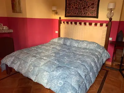 a bedroom with a bed with a blue comforter at Mondello Room in Mondello