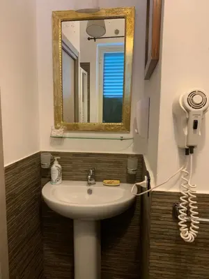 a bathroom with a sink and a mirror and a phone at Mondello Room in Mondello