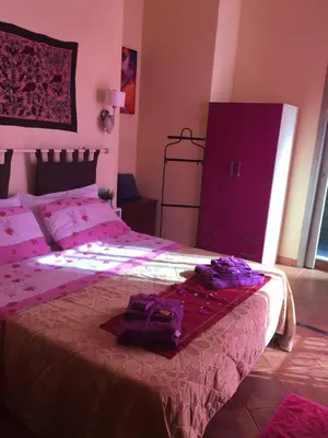 a bedroom with a large bed with pink sheets at Mondello Room in Mondello