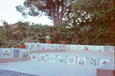 a white fence with a wall with stickers on it at Two Steps From The Sea in Scopello