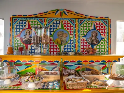 a table with food on it with a colorful wall at Tra Le Braccia di Morfeo in Terrasini
