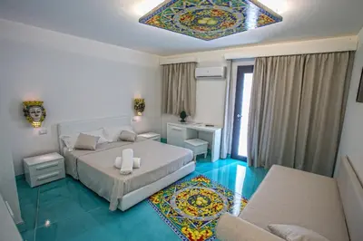 a bedroom with a bed and a living room at Tra Le Braccia di Morfeo in Terrasini