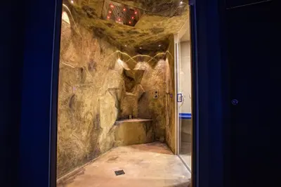a bathroom with a stone wall with a toilet in it at Tra Le Braccia di Morfeo in Terrasini