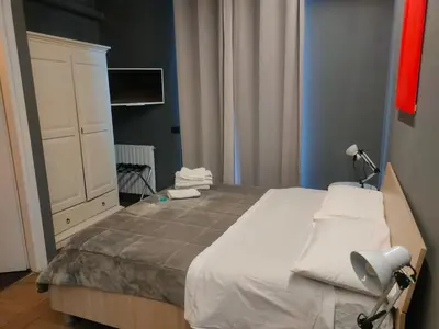 a bedroom with a large bed and a white cabinet at Dimora Villareale in Palermo