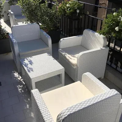 a group of wicker chairs and tables on a patio at Dimora Villareale in Palermo