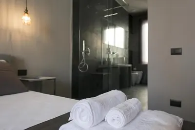 a bedroom with towels on a bed and a shower at Dimora Villareale in Palermo