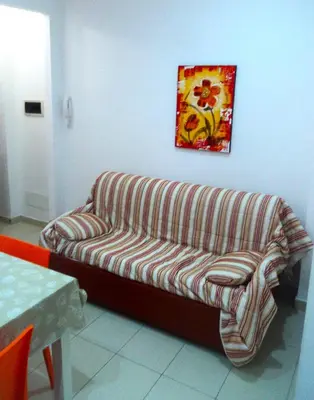 a couch in a room with a painting on the wall at Orange House a Castellammare del Golfo in Castellammare del Golfo