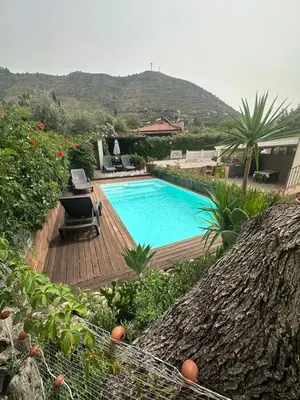 a swimming pool on a wooden deck with chairs at Villa Giorgia in Cefalù