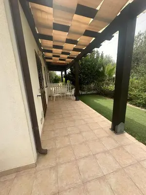 a patio with awning and tables and chairs at Villa Giorgia in Cefalù
